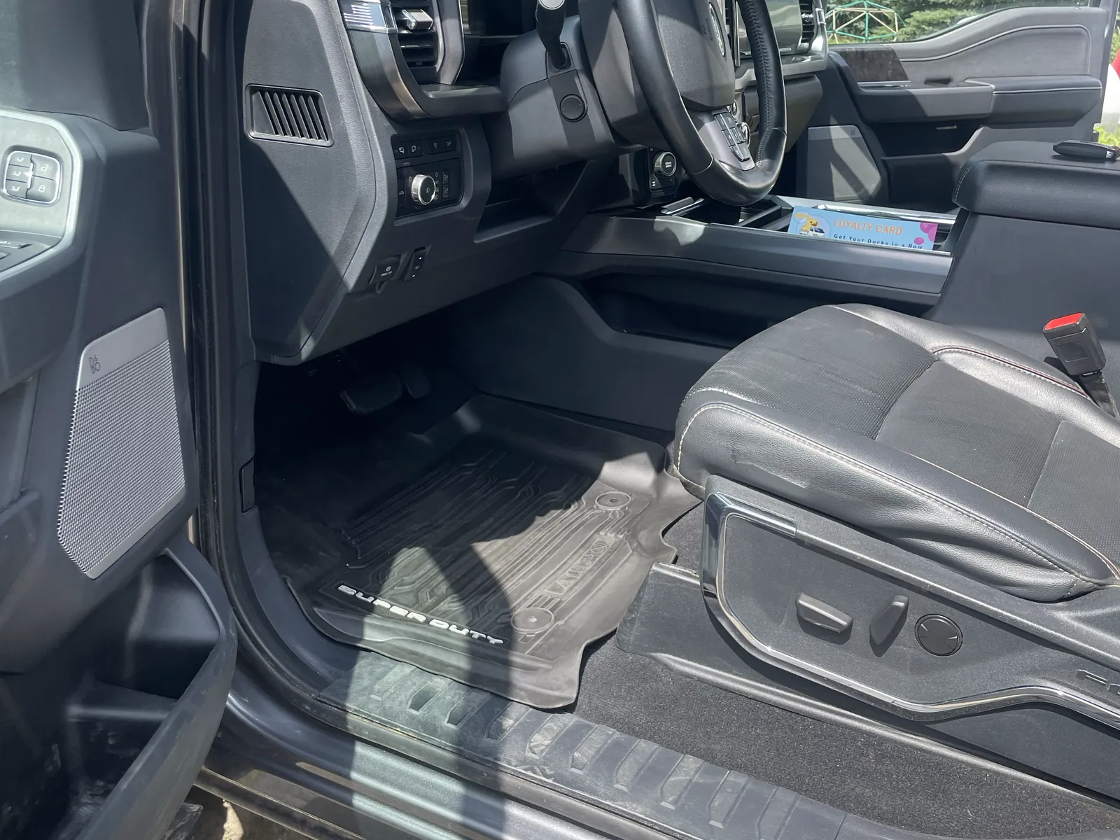 The same footwell after: mats scrubbed back to black, sill and seat base clean.